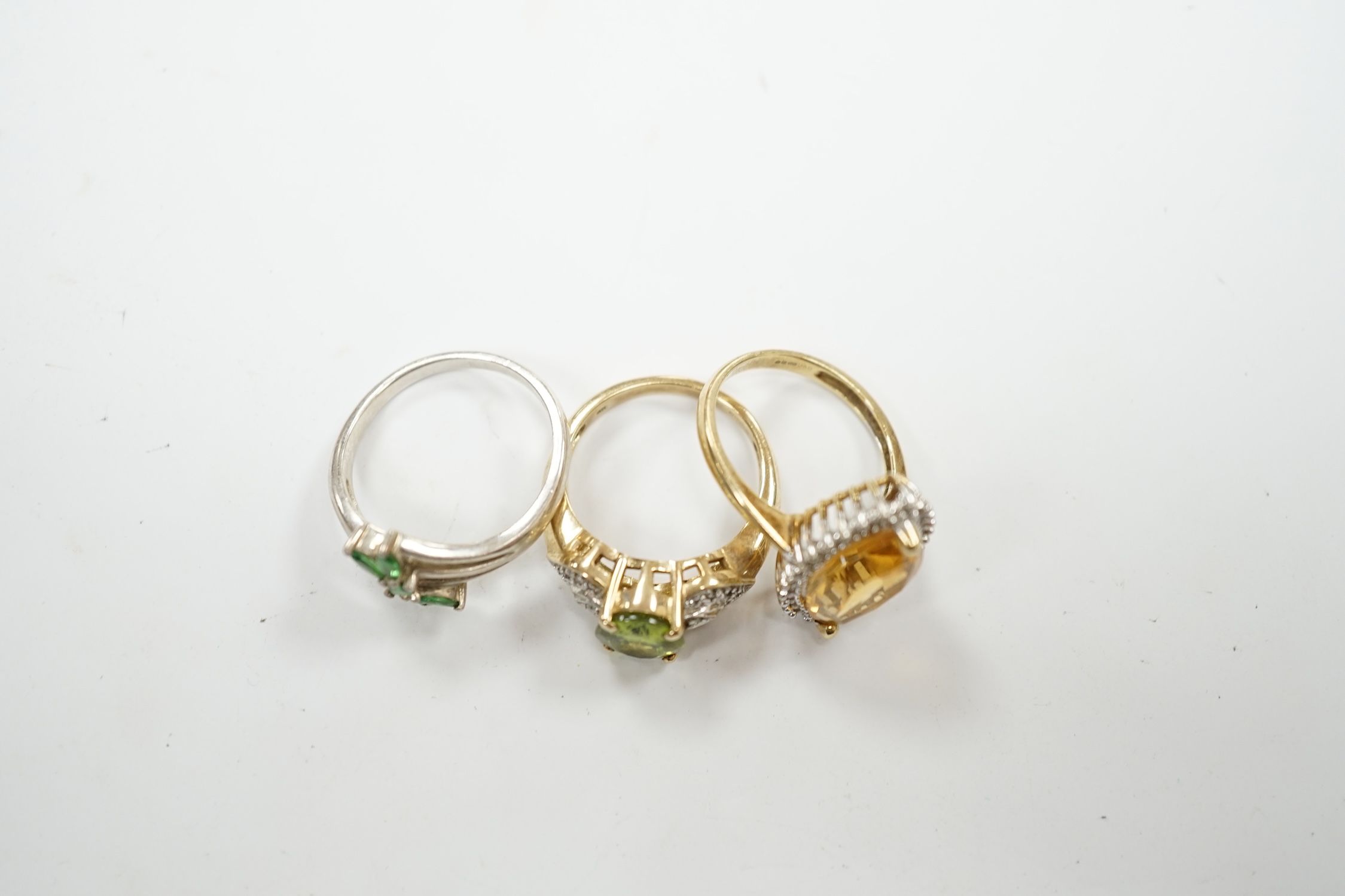 Two modern 9ct gold and gem set dress rings, including citrine and diamond chip and peridot and diamond chip, gross weight 8.2 grams, together with a 925 ring. Condition - fair to good